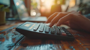 Close-up of a hand pressing buttons on a calculator, capturing the action of performing calculations. The image emphasizes the focus on numbers and financial tasks, symbolizing budgeting, accounting, or financial planning.